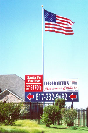 U.S. flag flying flying behind a large D. R. Horton branded sign