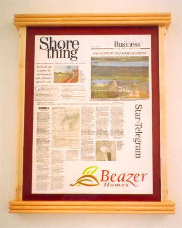 A print of a newspaper article mounted in a custom wood frame