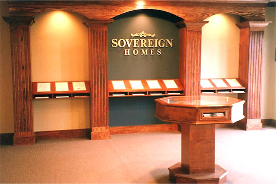 Elegant wood shelving displaying house floorplans in a Sovereign Homes sales office