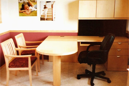 A typical Novikoff Furniture Metaplan desk in a light wood color with two guest chairs an one executive chair
