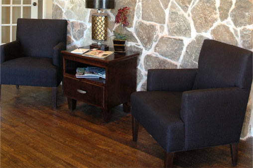 Two Novikoff Furniture lounge chairs with square arms and backs and wood legs