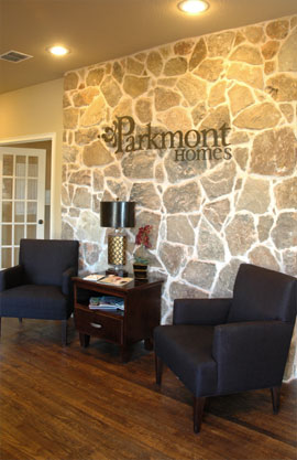 A powder coated aluminum logo mounted on a stone wall