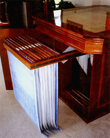 An elegant wood site map table with floorplan storage below