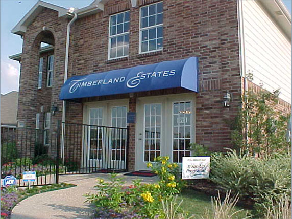 A blue awning with a curved front mounted on a model home