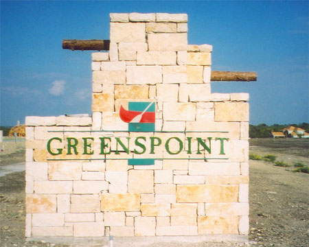 Staircase-shaped stone monument with the Greenspoint logo mounted on the front